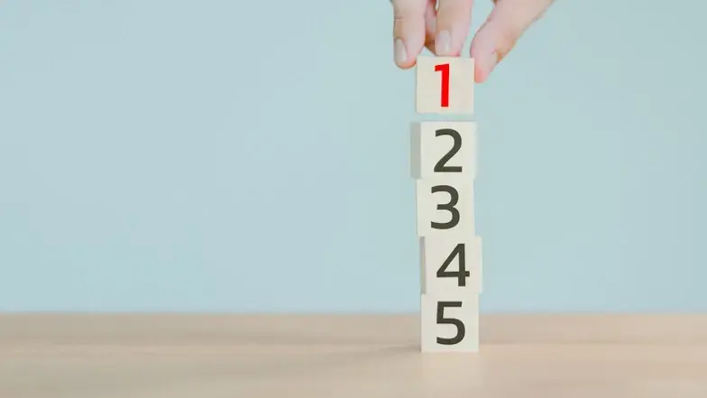 Hand bildet Turm aus Würfeln von 1 bis 5